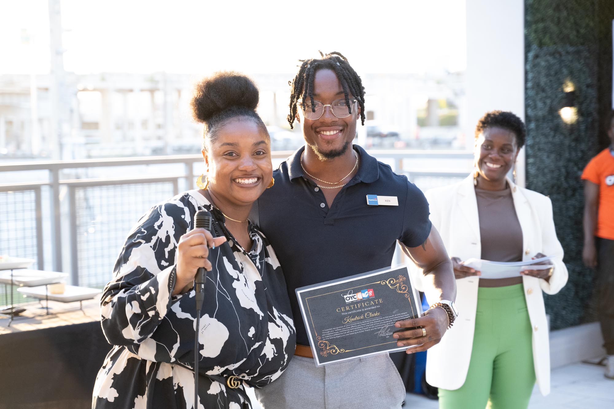 A man and a woman display a certificate
