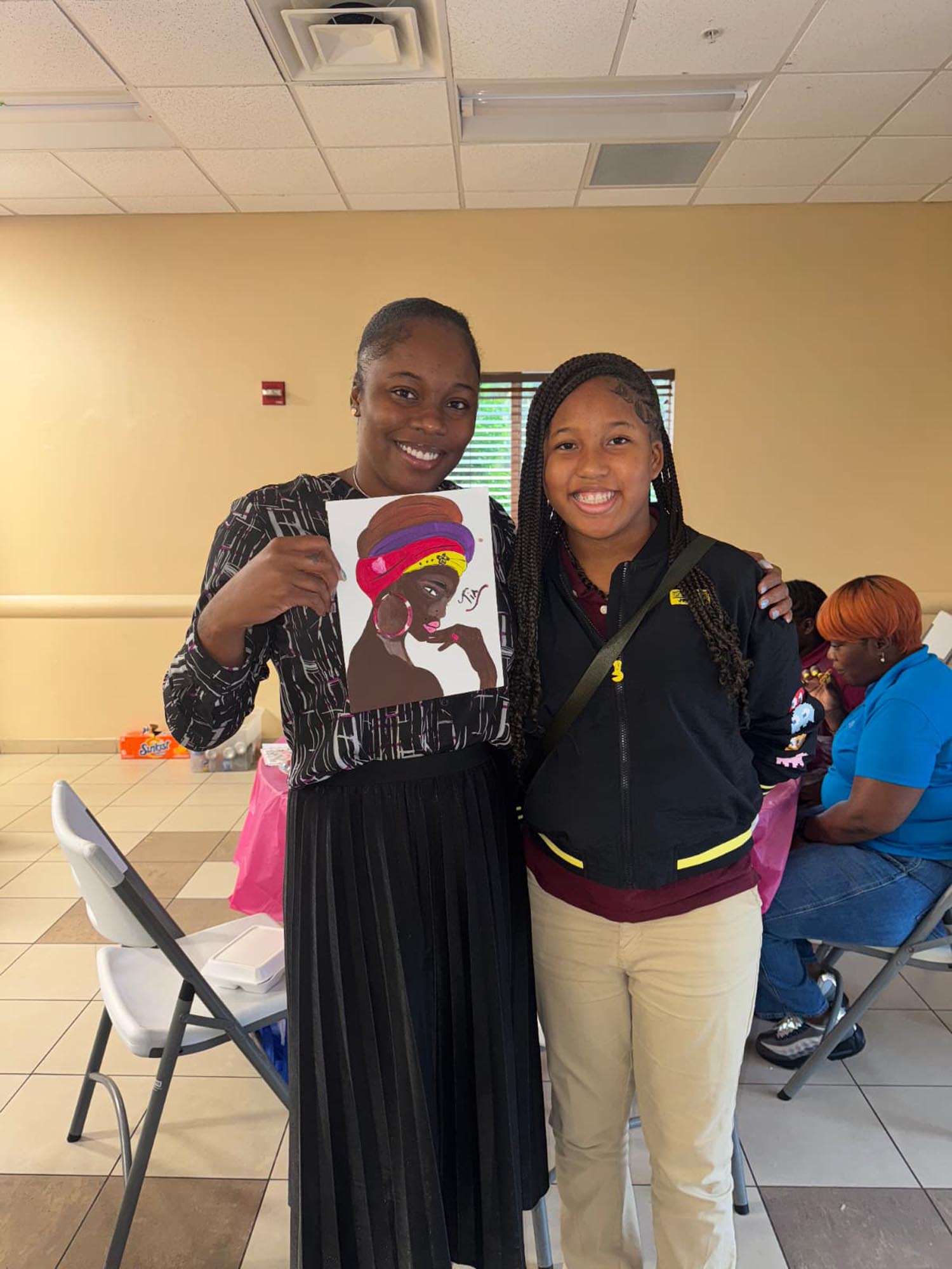 a teenage girl and instructor display a paining done by the student