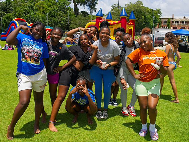 a group of young girls poses for a group photo on a field