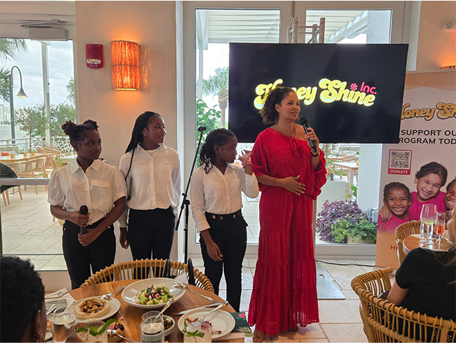 Tracy Wilson Mourning speaks at the Circle of Influence brunch. 3 young girls stand beside her.