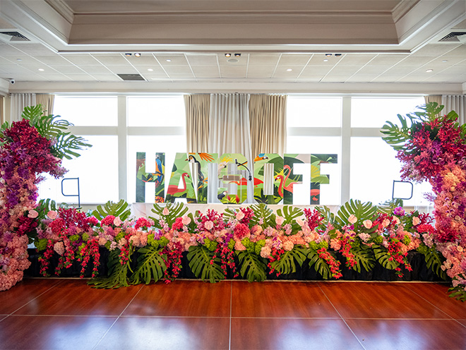 Hats Off sign with surrounding floral arrangements