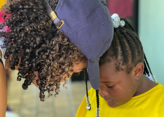 a woman and young girl have a close conversation