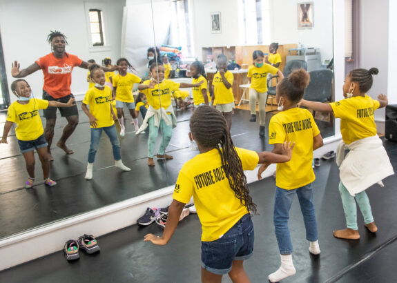 a group of girls dances in a studio with an instructor